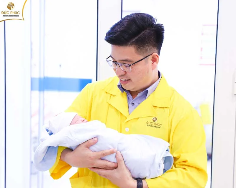 Em bé trong vòng tay hạnh phúc của bố